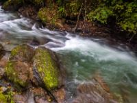 Der Talbach umtost schrägliegende, mit Moos bedeckte Felsblöcke